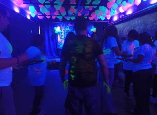 Grupo de adolescentes en la fiesta con iluminación azul y violeta