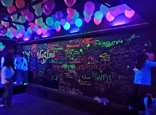 Salón decorado con globos y muro de graffiti para una fiesta de adolescentes