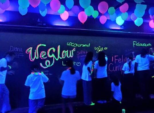 Pista de baile iluminada con luces de colores durante una fiesta de adolescentes