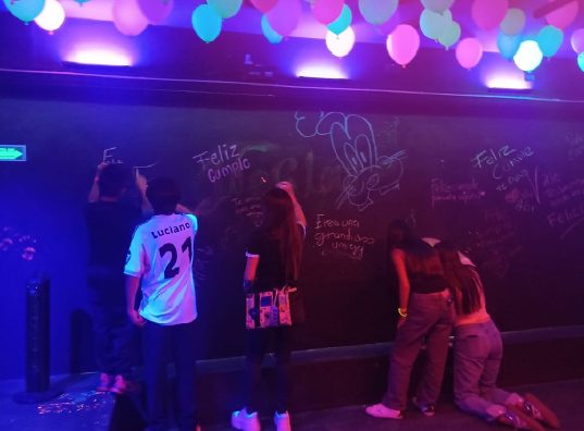 Adolescentes firmando el muro de graffiti fluorescente