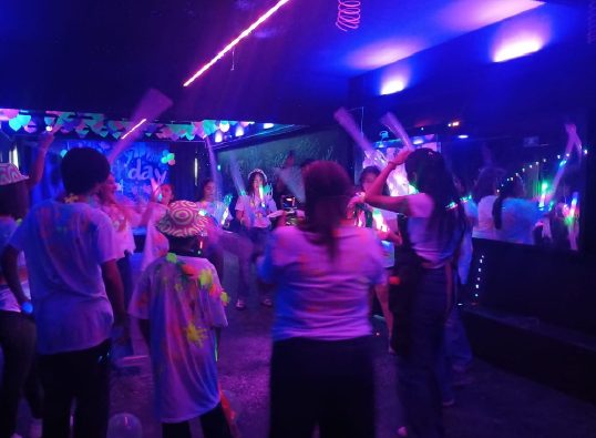 Adolescentes con barras de espuma luminosa en la pista