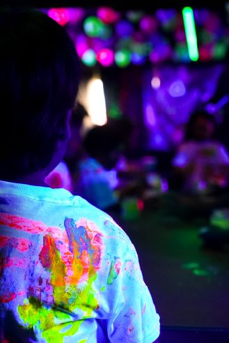 Niño con la playera pintada de colores fluorescentes
