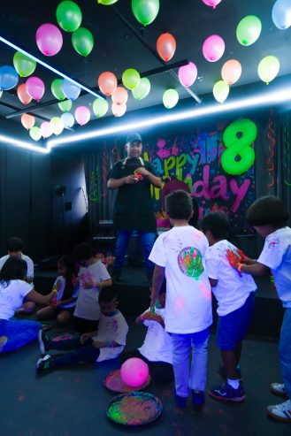 Salón decorado con globos y letras luminosas de cumpleaños