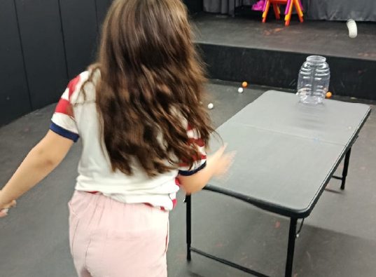 Niña en la zona de mesas de la ludoteca de WeGlow