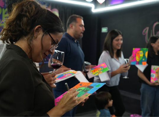 Asistentes conviviendo con iluminación de neón durante una activación
