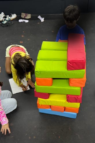 Niño construyendo una torre con bloques de espuma de colores