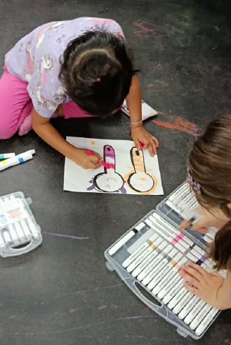 Niña coloreando en la mesa de arte de WeGlow